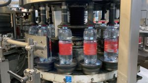 Ligne de mise en bouteille PET 12 000 bph pour eau naturelle et pétillante, avec souffleuse Krones, remplisseuse Simonazzi et étiqueteuse Contiroll.